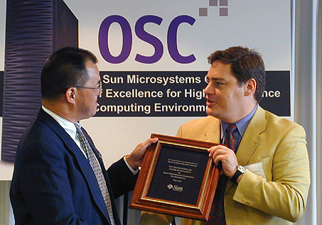 Chancellor Rod Chu accepts a plaque recognizing OSC as a Sun Center of Excellence.